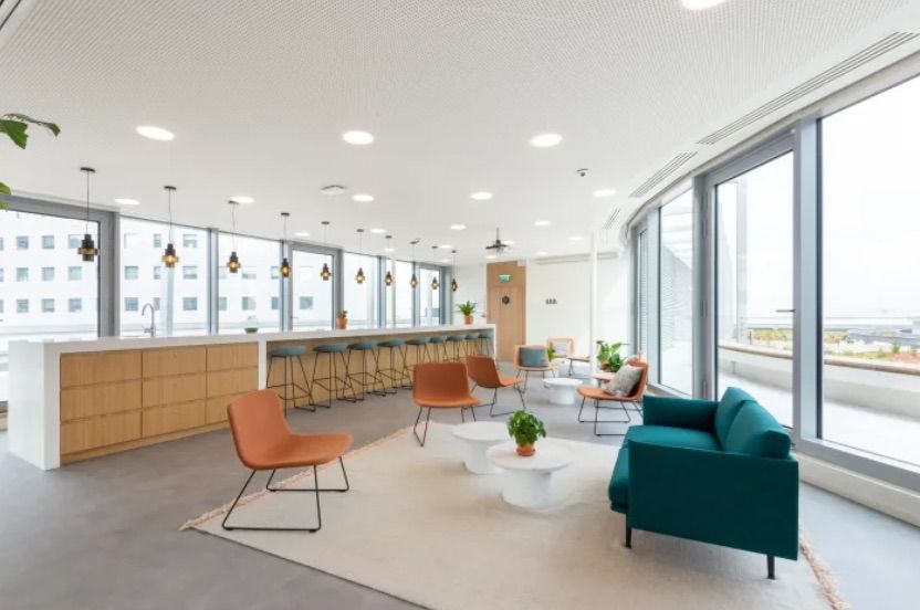Großer heller Wartebereich mit Theke, einzelnen Stühlen und Sofa